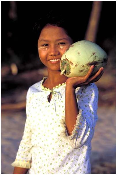 Young Bama girl with a coconut in pathein market - Myanmar
