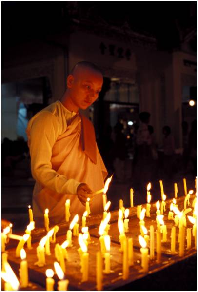 nonne allumant une bougie à la pagode Shwedagon, Yangon